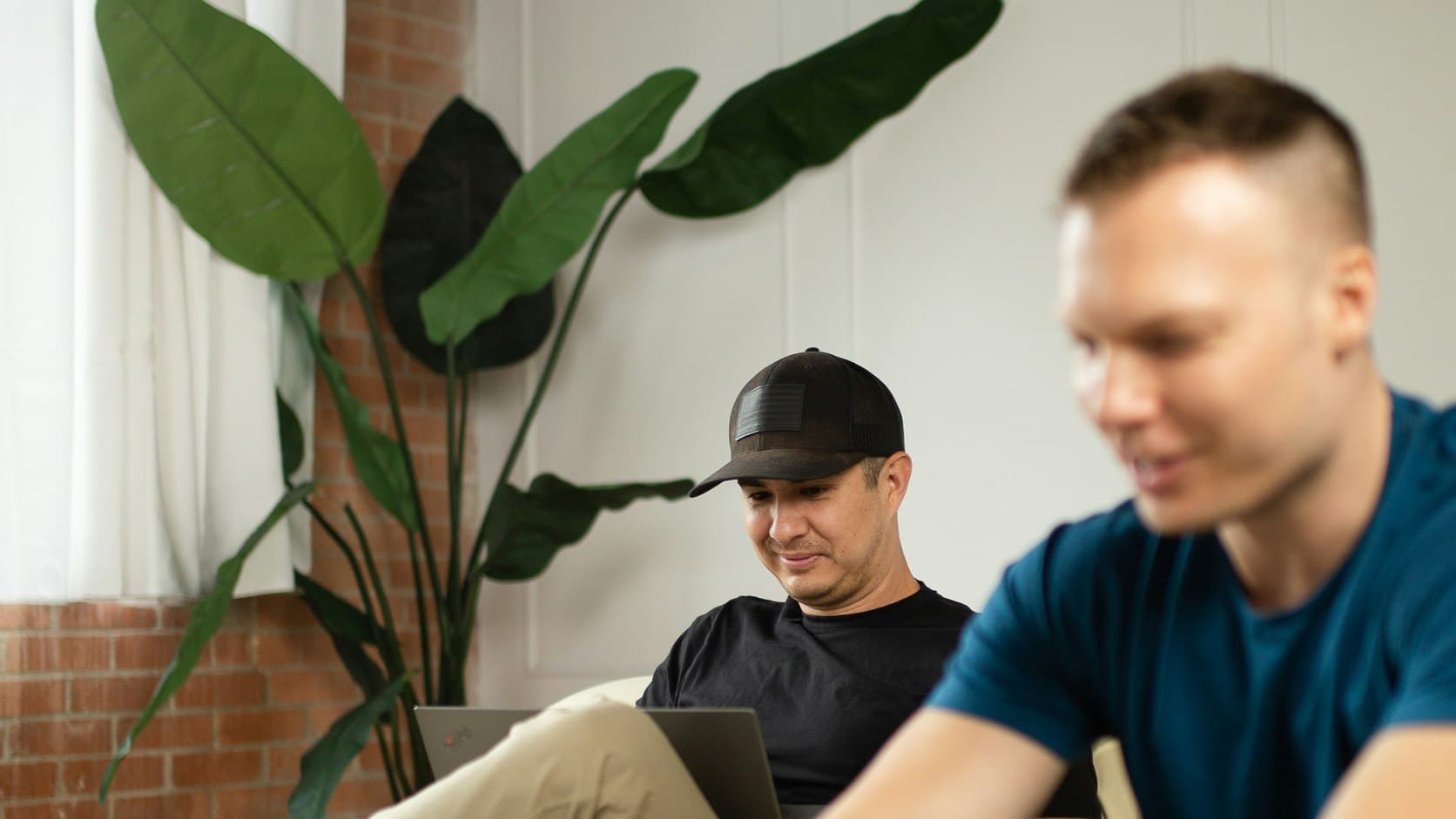Two creators working side by side on laptops