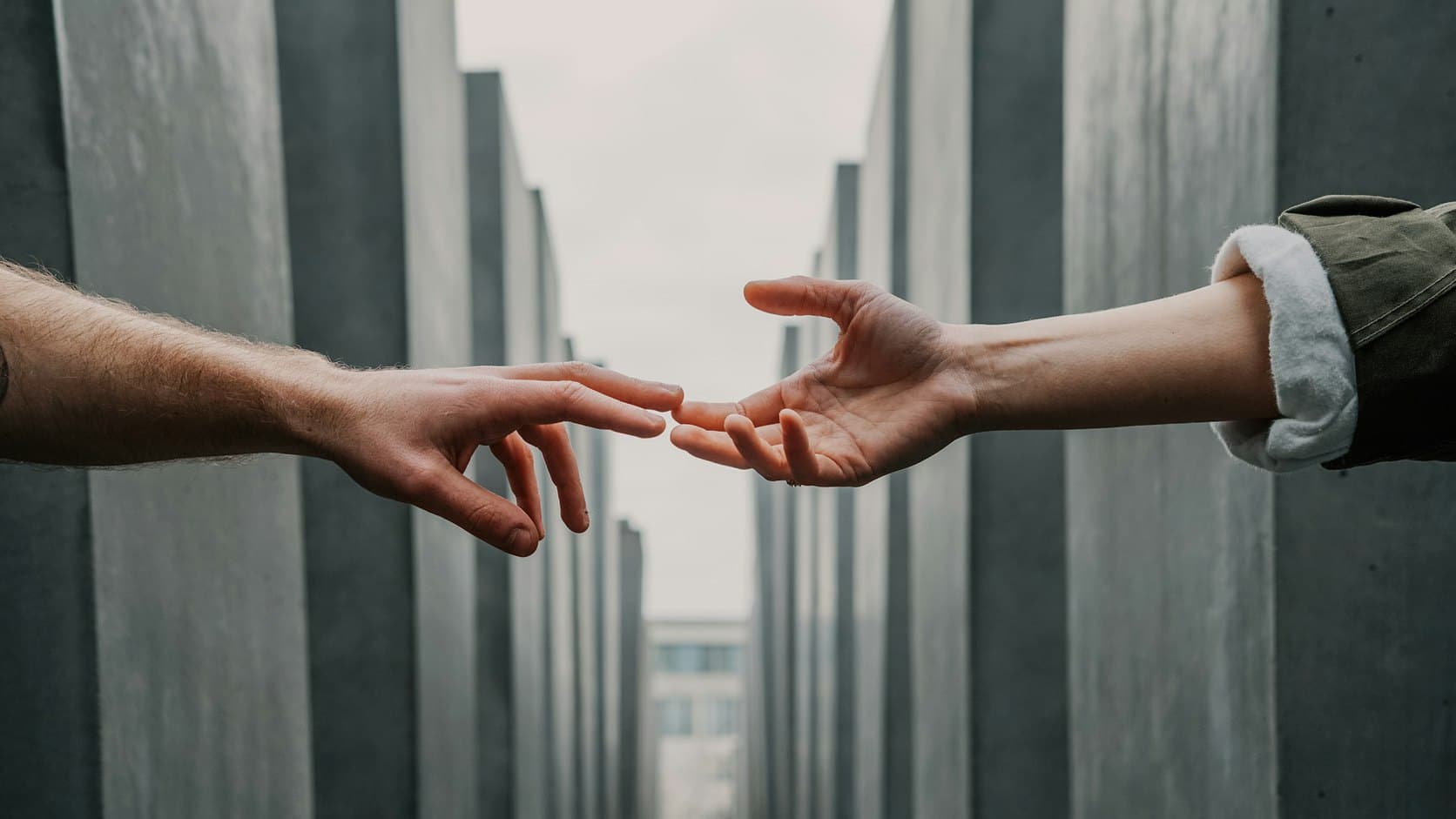 Two hands reaching toward each other in agreement